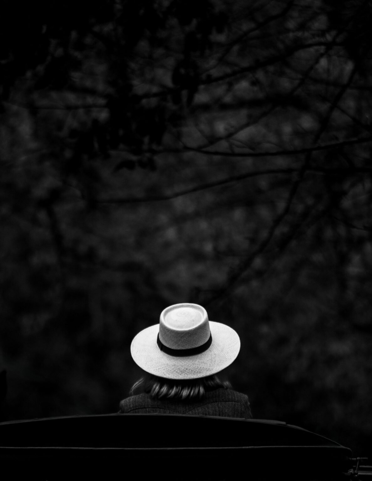Black and white portrait of a person in a hat seen from behind, captured outdoors in Chascomús, Argentina.